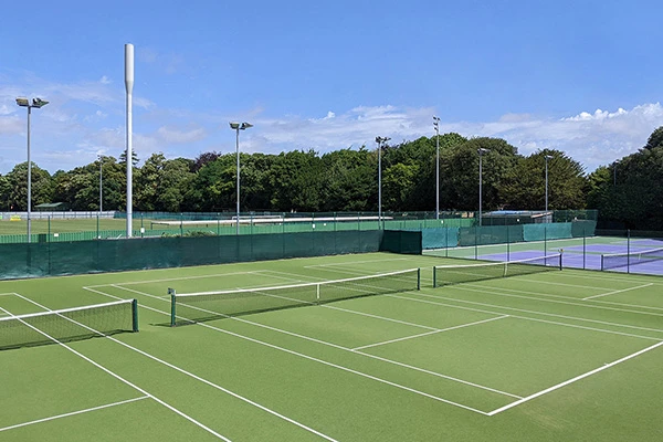 Astro and hard tennis courts in the summer sunshine.